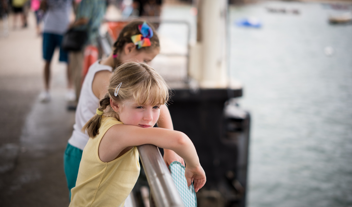 8月初的香港南丫岛十分炎热,小女孩正在趴在栏杆上吹海风,当我举起