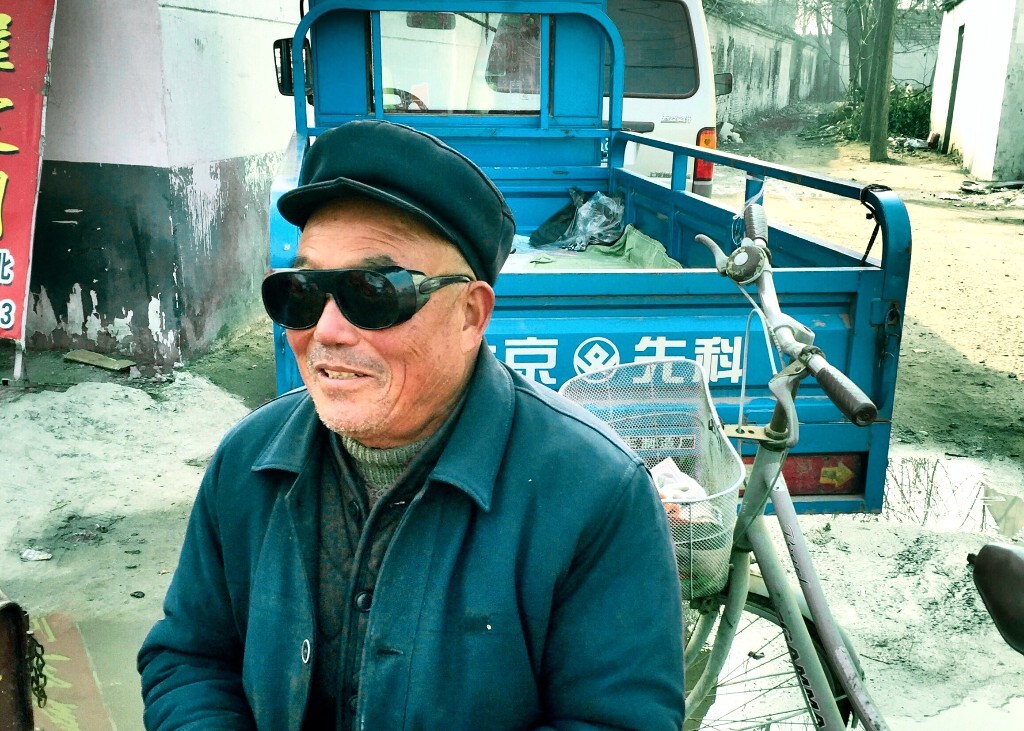 爷爷的孙子在上海上班，这副眼镜就是孙子送个他的，他很幸福的向路人炫耀。