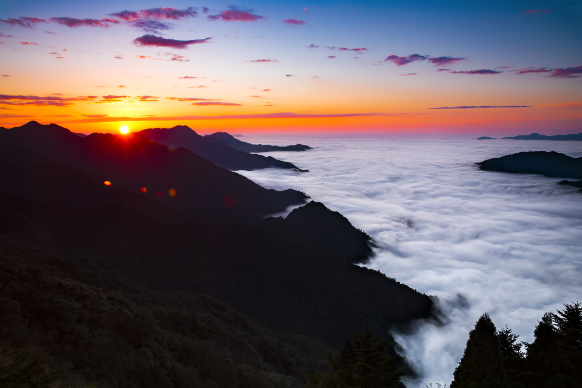 在山顶看茫茫云海中夕阳缓缓落下,磅礴气势的云海中晚霞也不甘示弱地