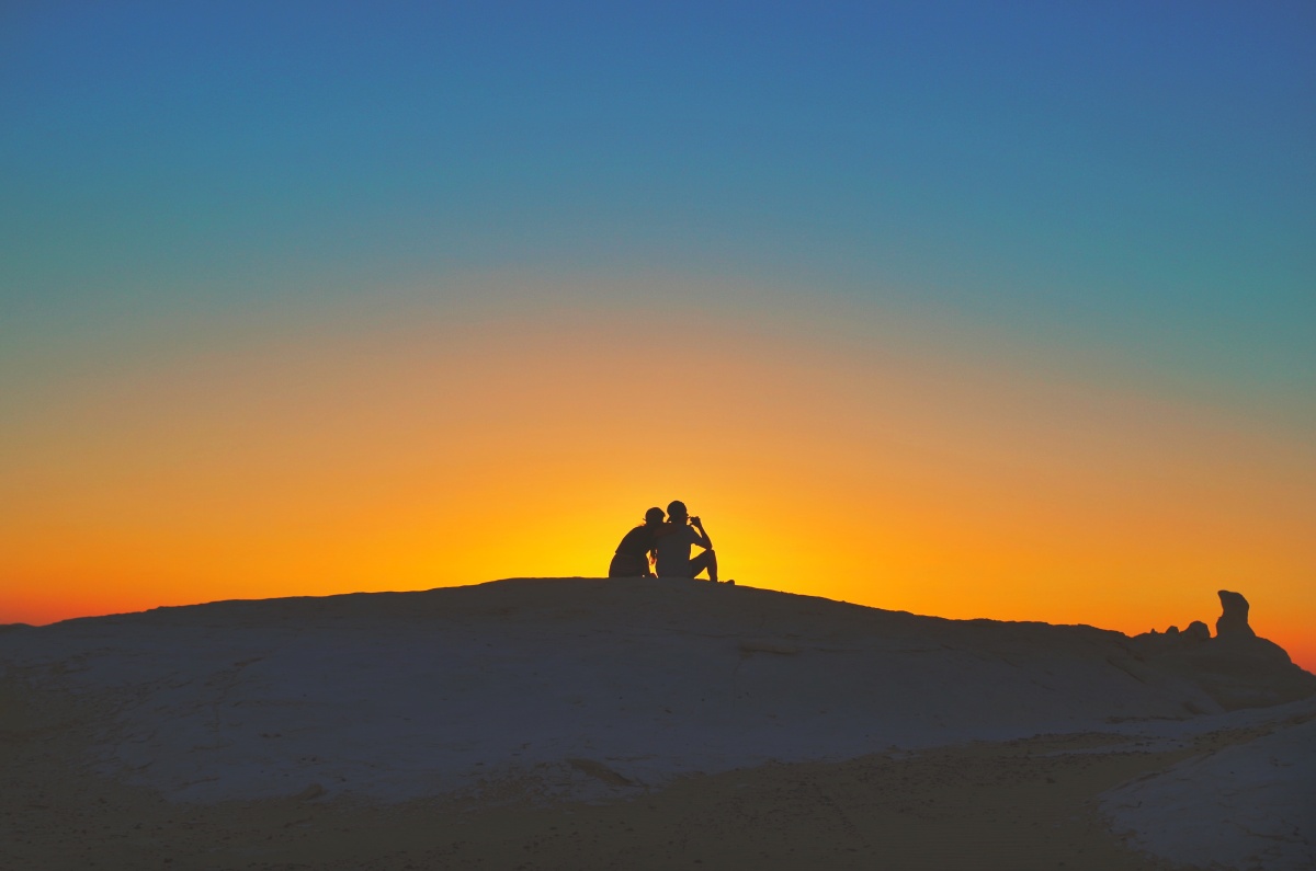 撒哈拉日落下偎依的年轻恋人