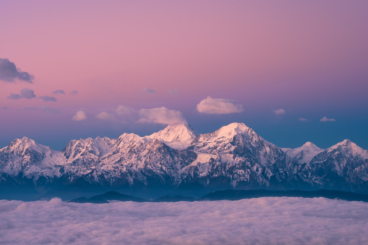 贡嘎雪山就像少女一般披上了粉色披肩,娇羞的屹立在云海之上