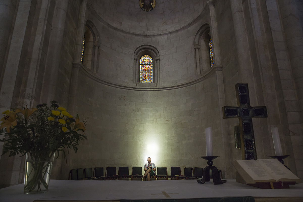 2015年6月10日，耶路撒冷唯一的更正教教堂——路德会救赎主堂里，一位信徒手捧圣经沐浴在透过玻璃穹顶的光线下。