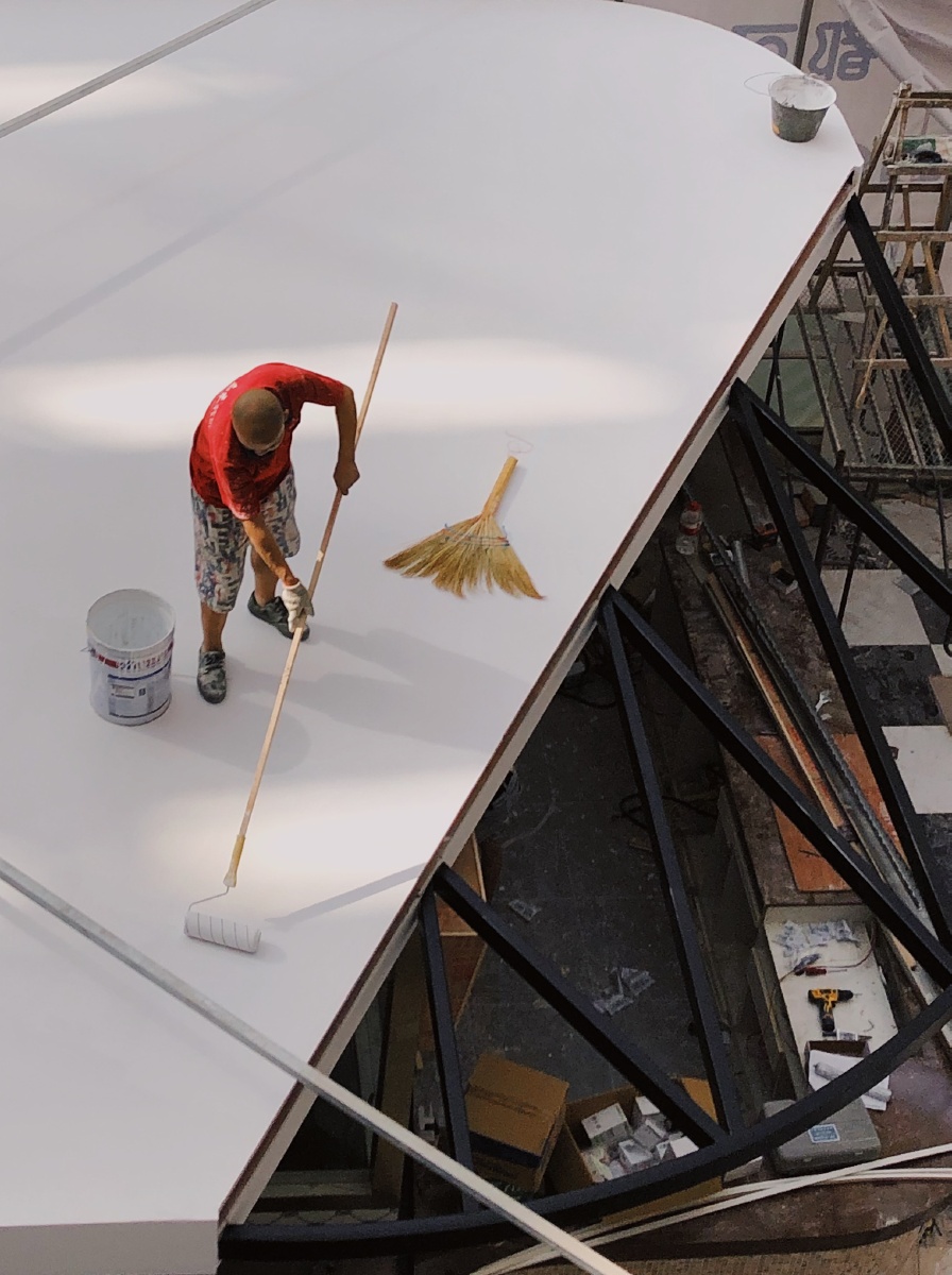 对角线切分画面,刷白漆的人在淡黄的光中