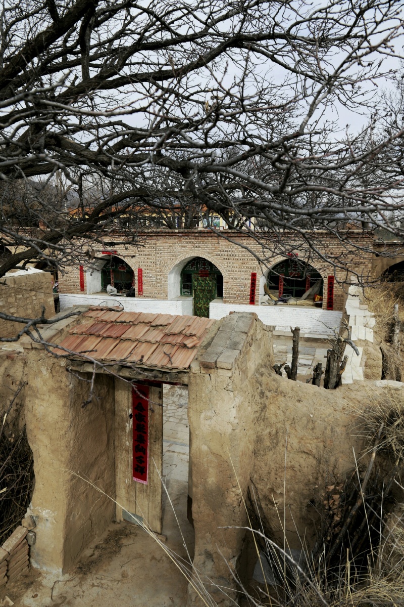 来到一户人家院外,透过破败的土墙可以看到挂了砖面的土窑还是整整齐