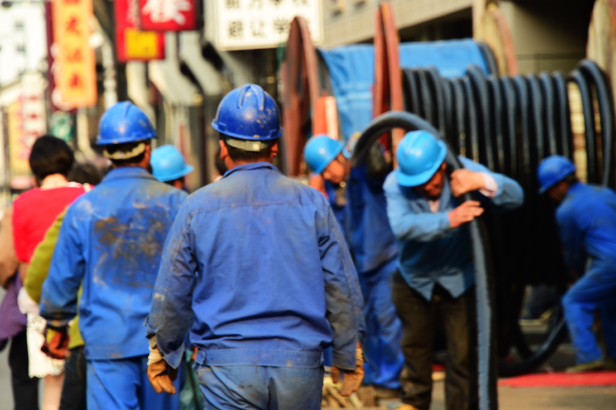 电力工人在吴山广场旁的马路边埋设电缆辛勤的在工作.