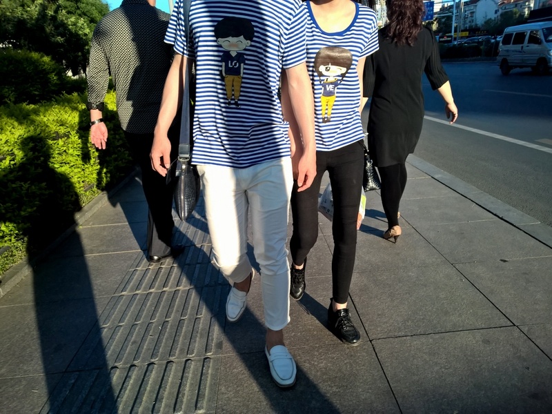 街头上一对情侣迎面走来,两旁一对黑衣男女反向走去.