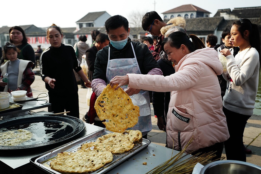 葱油饼用面粉加葱再加食物添加济做在成饼,然后用面棍推平推薄,中间要拉出空洞,放在菜油里炸,