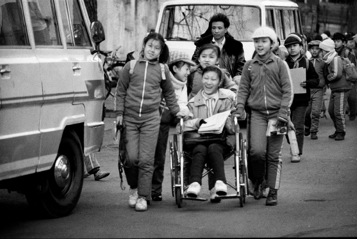 a05同学情--回思那个年代物资上虽不丰富,还很土,但人们的情感确是土中纯仆与真切,这中间的残疾孩子就是每天在同学的接送下来上学,这所学校就在我原来的家附近几呼每天我都能见到她们,1989年摄于沈阳.jpg