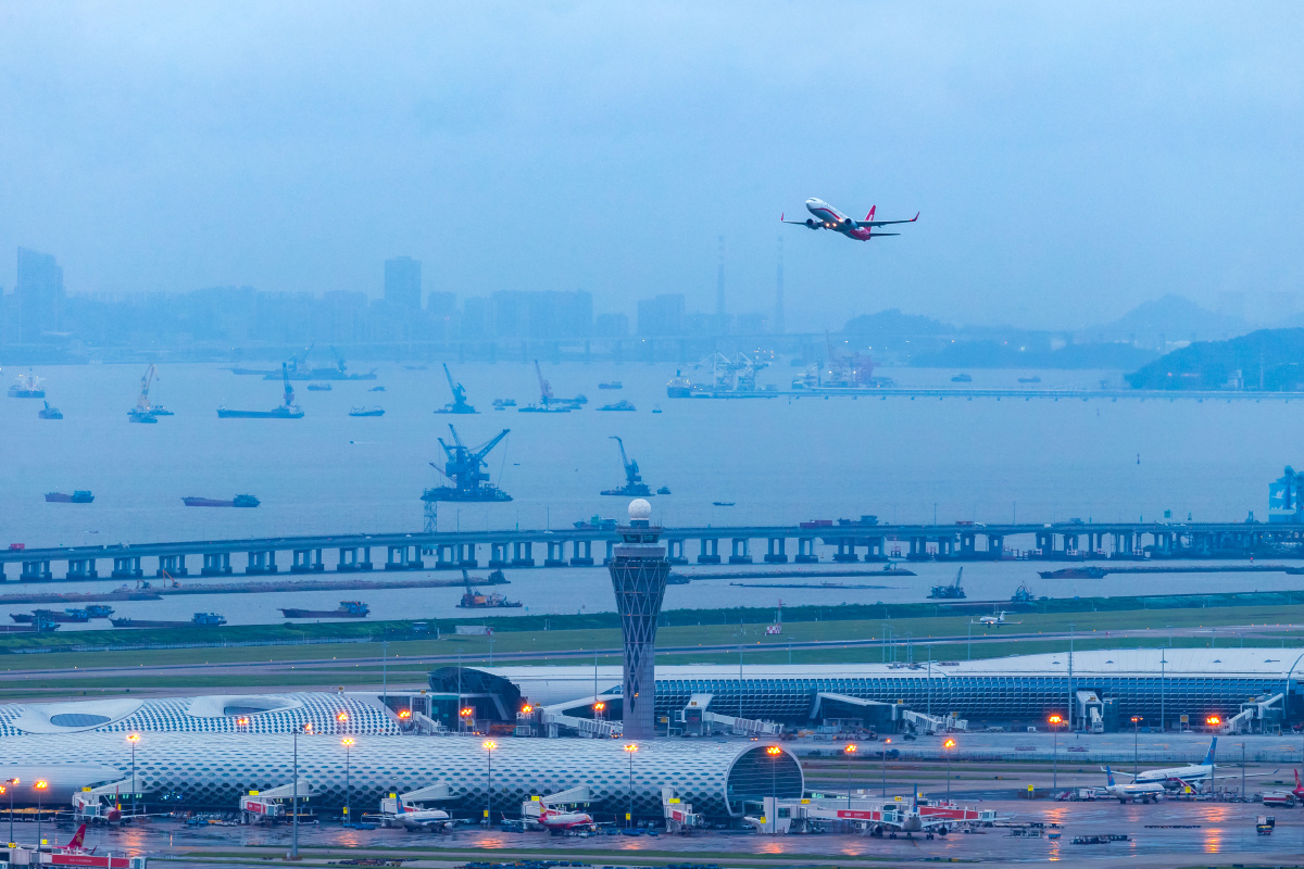 上海航空公司飞机飞过深圳机场塔楼