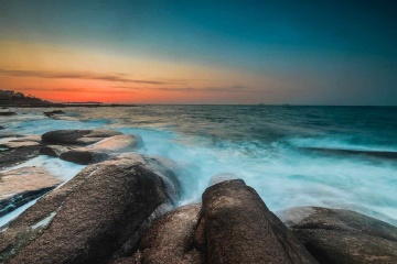 青岛朝霞中的浪与礁