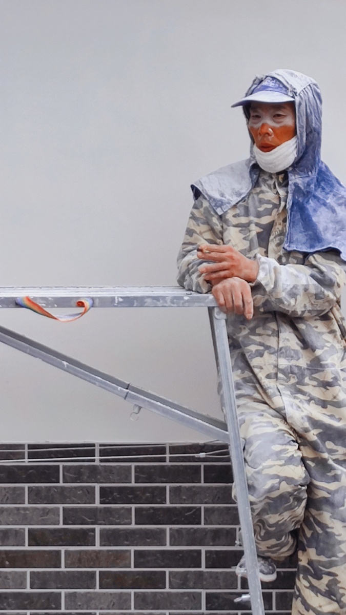 在朋友的工地偶然看见一个粉刷墙漆的工人正倚架休息神态安逸自然