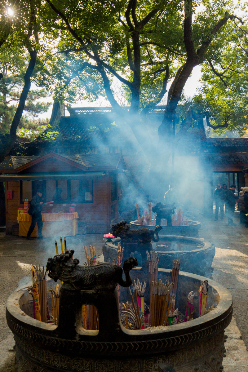 寺庙前,光线透过缝隙,与缭绕的香雾构成美丽的景色