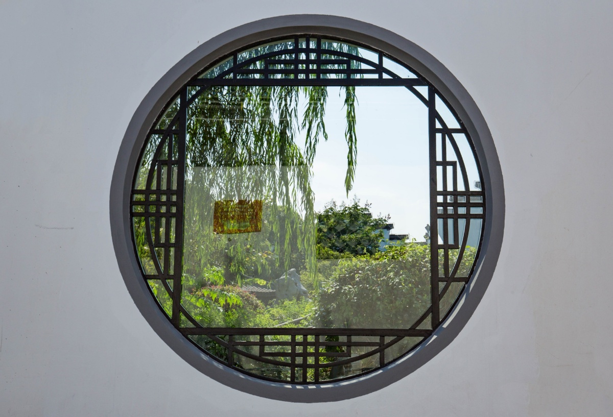 无锡荣毅仁纪念馆的围墙上开了一个透窗从床中可以观看馆内花园风景这