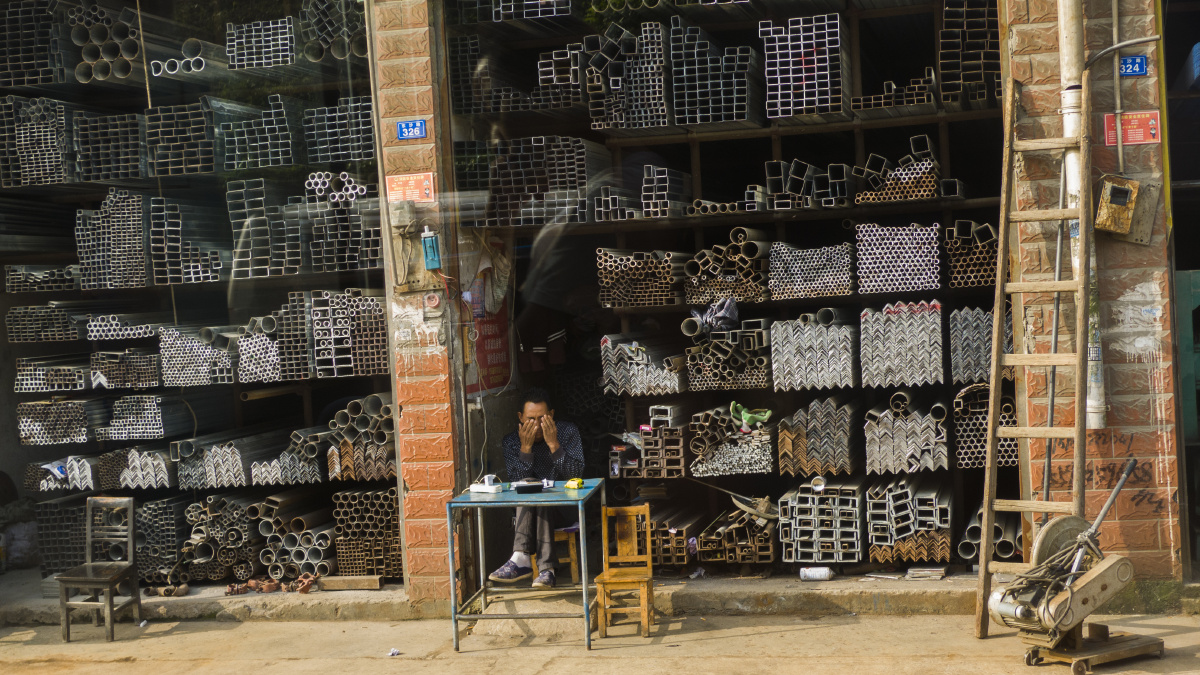 一家钢材铺,老板在睡眼中已经开门迎生意了