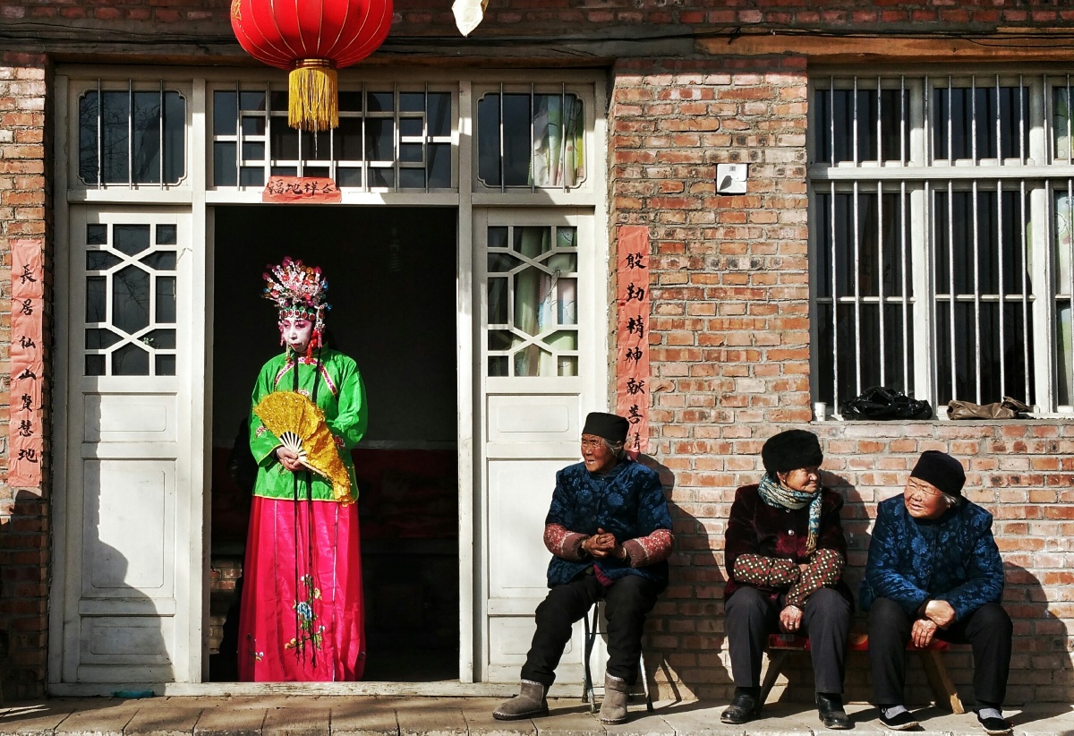 山上的庙里搭起戏台,三三两两的老人坐在阳光里听戏.