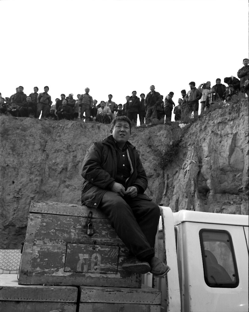 8、2008年横山姜湾。剧团老板一面照看着行李,一面注视台上演出的情况。(2009年横山姜湾)