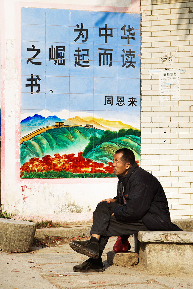 为中华之崛起而读书的广告牌下,人物的眼睛表露出渴望的神态.