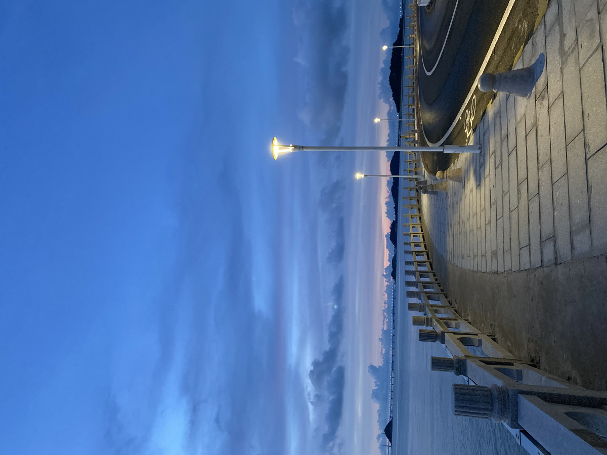 清晨,海边,柔和的路灯,空无一人的街道,蓝色的天空,散发静谧的气息.