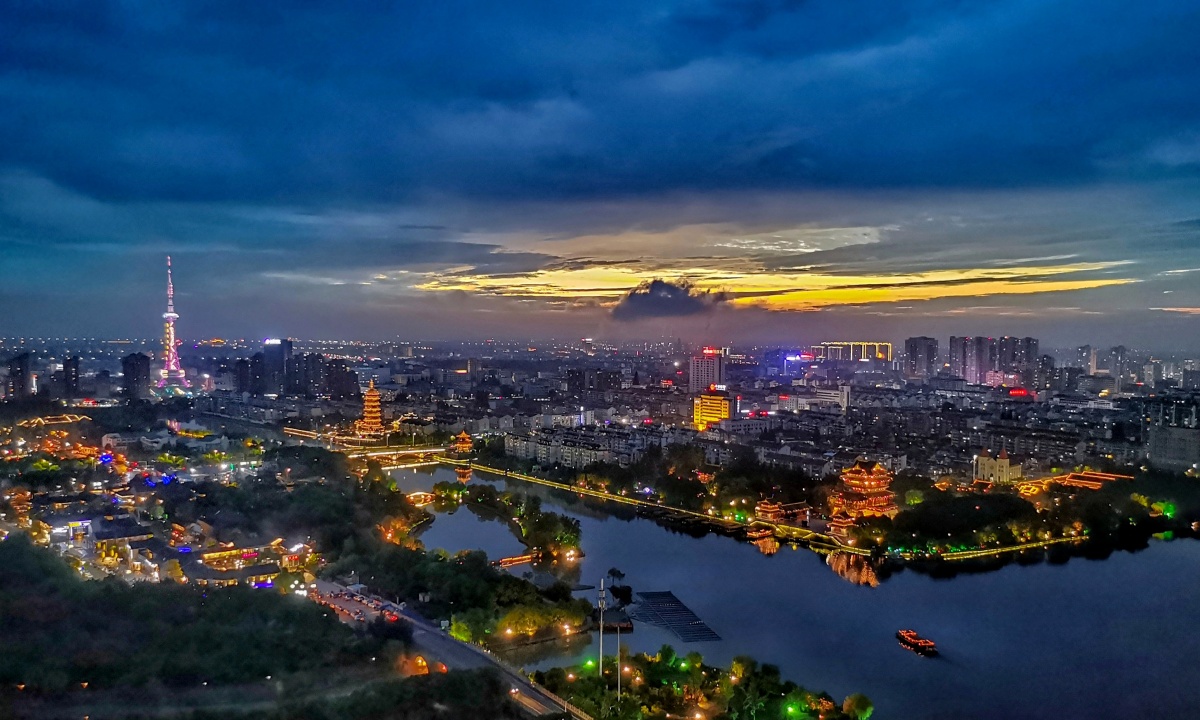 一线即将落幕的晚霞,衬映着华灯初放的泰州海陵区凤城河.