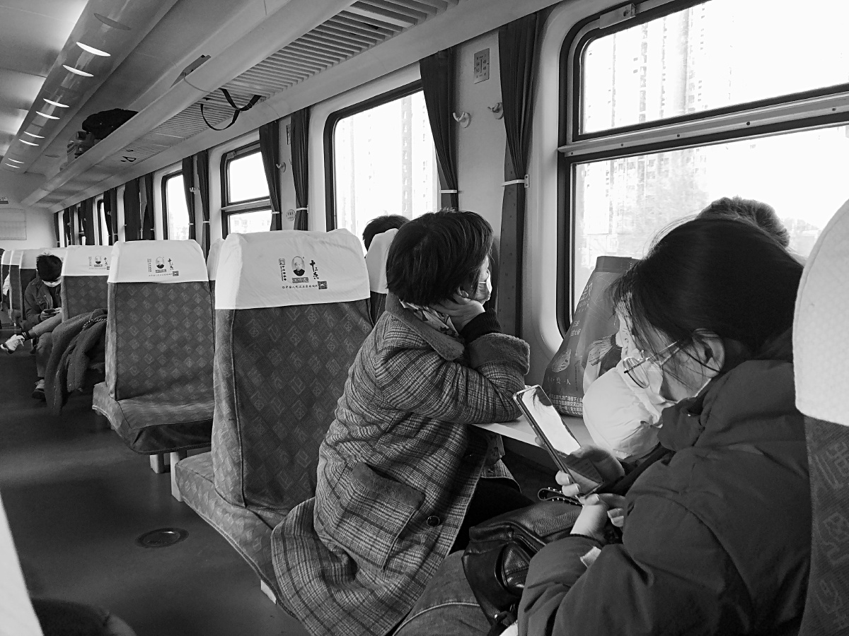 2021年临近春节途经郑州的火车上因疫情往常热闹的车厢里零星的旅客