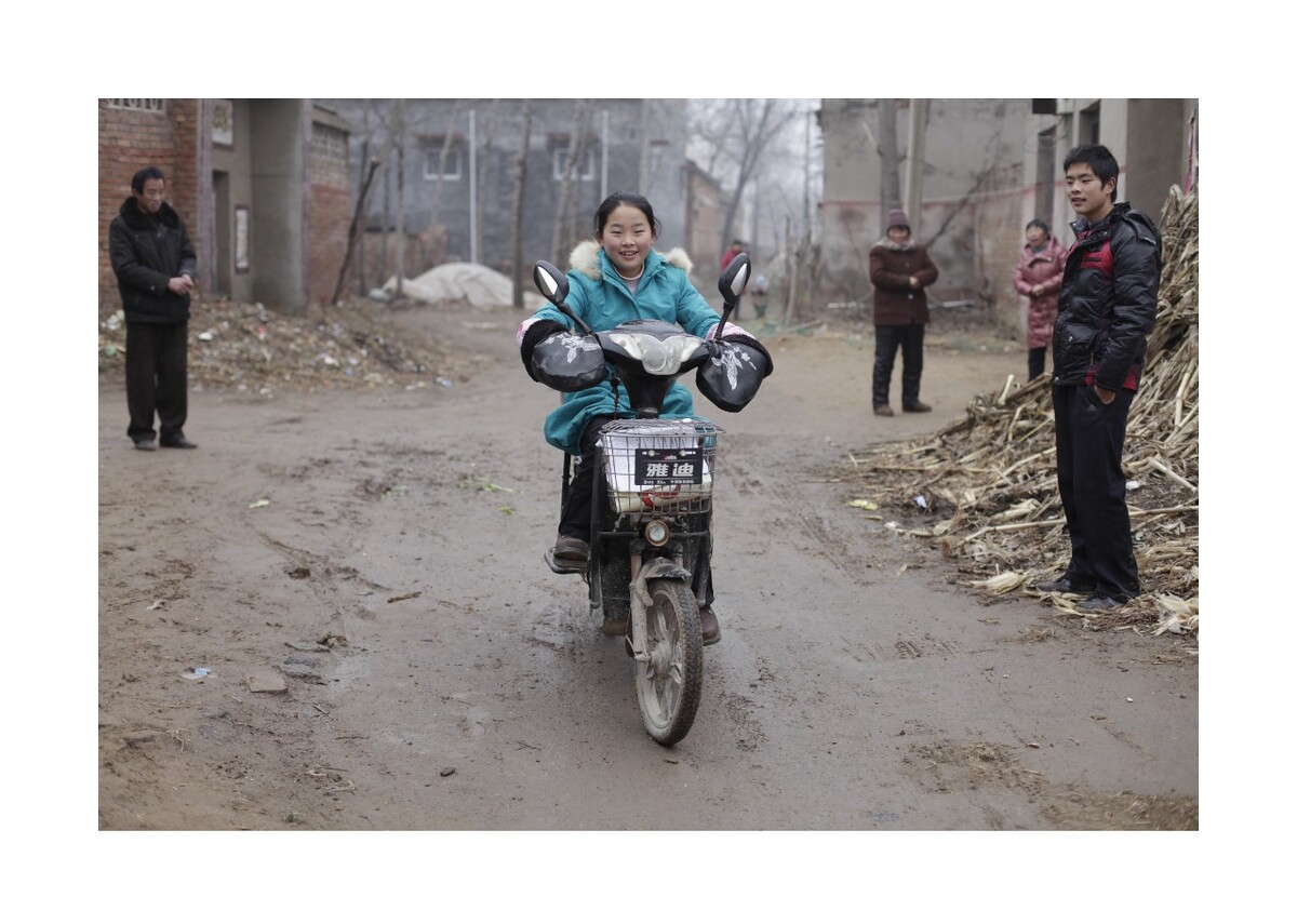 2012年2月河南兰考乡村。丽霞的女儿瑞卿跟随妈妈回老家过春节，学骑电动车。<br />
