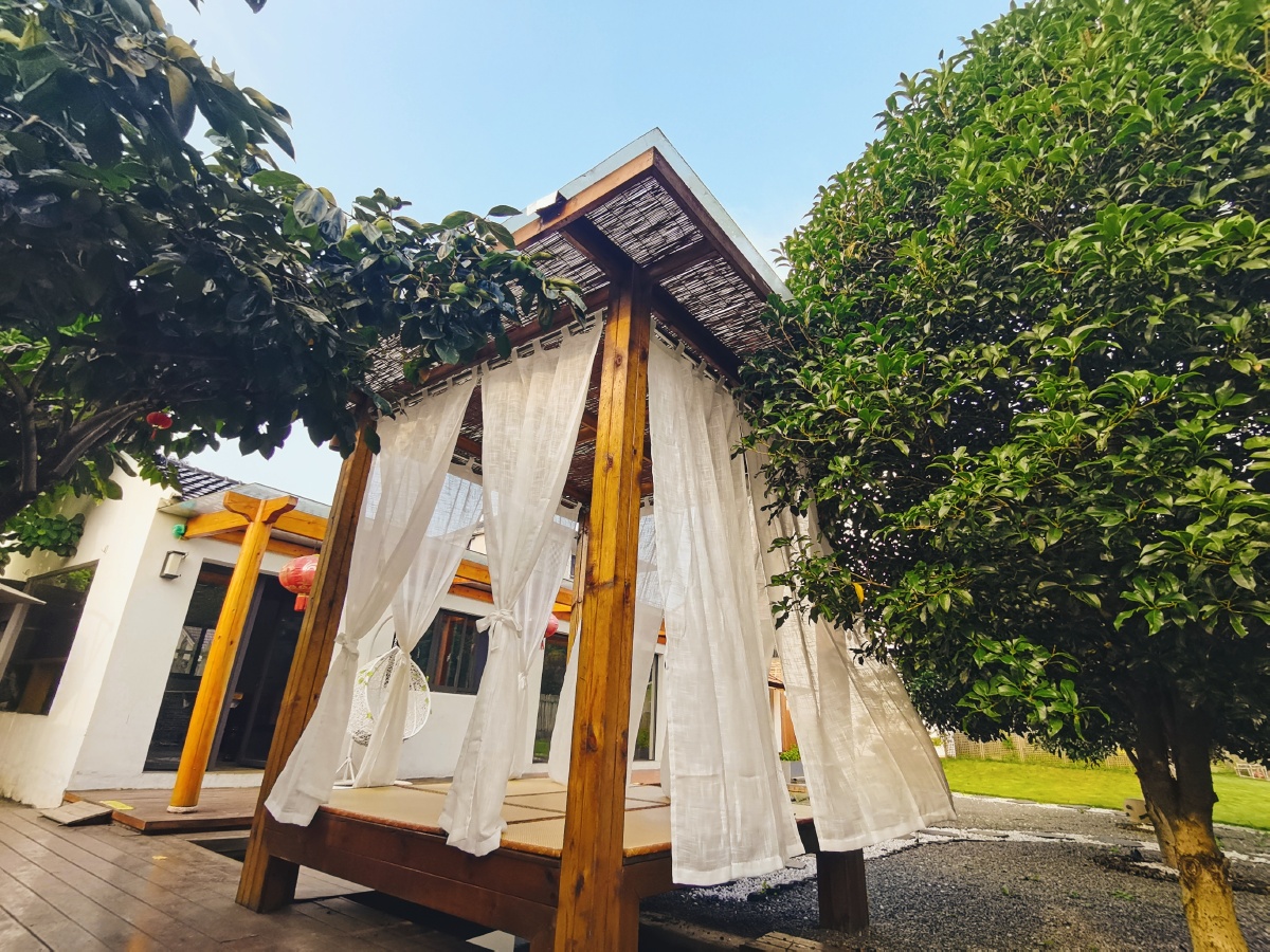 在自己家民宿的亭子上加了个纱幔