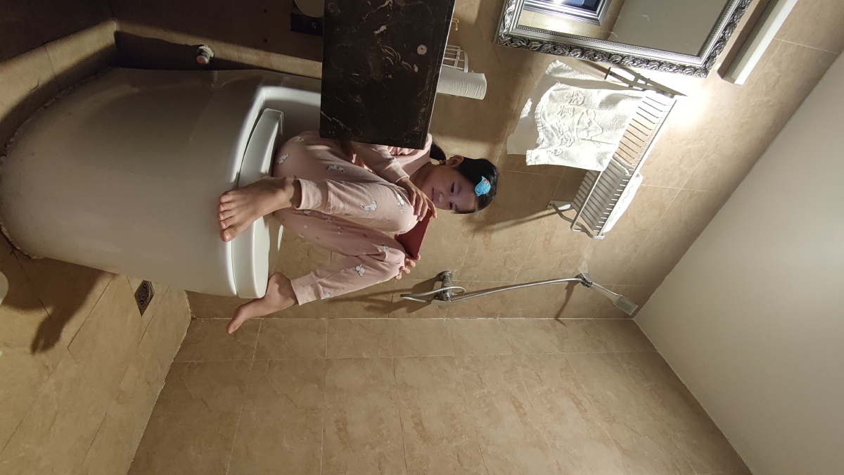 马桶上玩手机的小女孩因为在房间怕手机声音影响到大人睡觉就把自己关