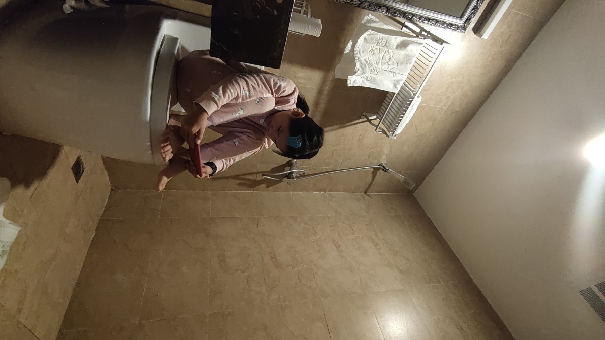 马桶上玩手机的小女孩因为在房间怕手机声音影响到大人睡觉就把自己关