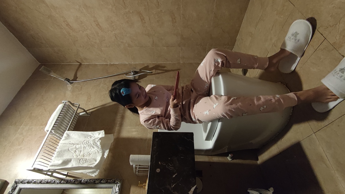 马桶上玩手机的小女孩因为在房间怕手机声音影响到大人睡觉就把自己关