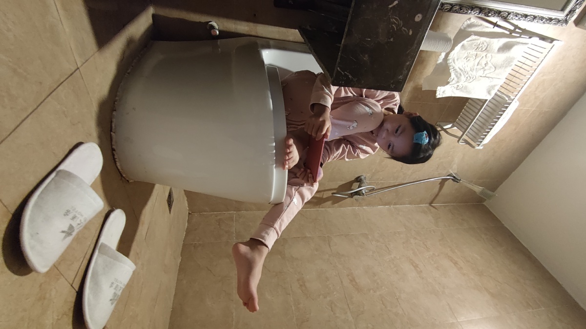 马桶上玩手机的小女孩因为在房间怕手机声音影响到大人睡觉就把自己关