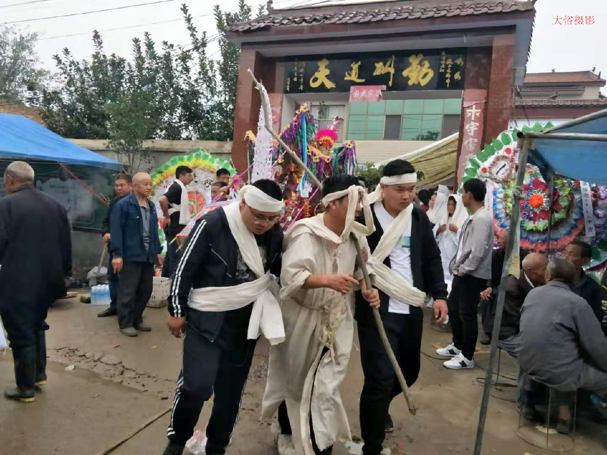 长子手执肩扛招魂幡.