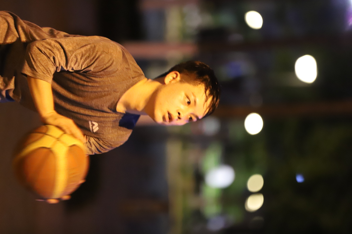 抓拍夜间路灯下街头篮球,人物投篮后的瞬间表情,原图无任何后期.