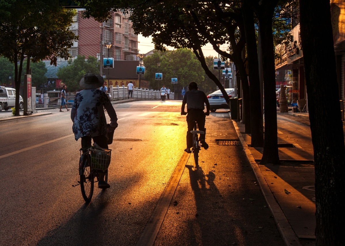 夏日的阳光照在街道,市民被沐浴在晨光中.