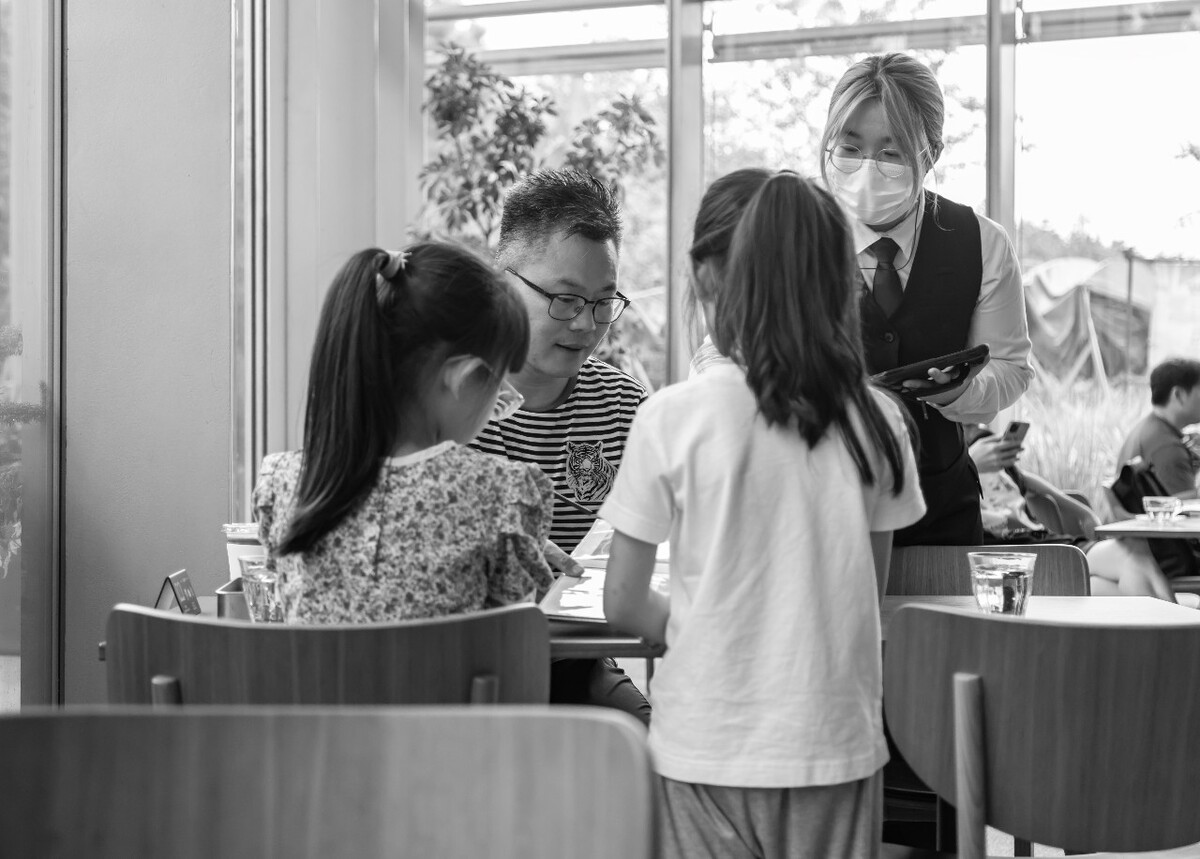 2021.06.26 杭州 鸢尾书店拍摄。吃饭的时候父亲给两个女儿讲吃饭礼仪,吃饭少说话,还给女儿们讲咖啡和红茶的区别还让两个女儿给自己打分,是一般啊,还是还不错啊。两个女儿还和上餐的服务员说谢谢。父亲还给两个女儿拍照,两个女儿都摆出了耶的手势。<br />