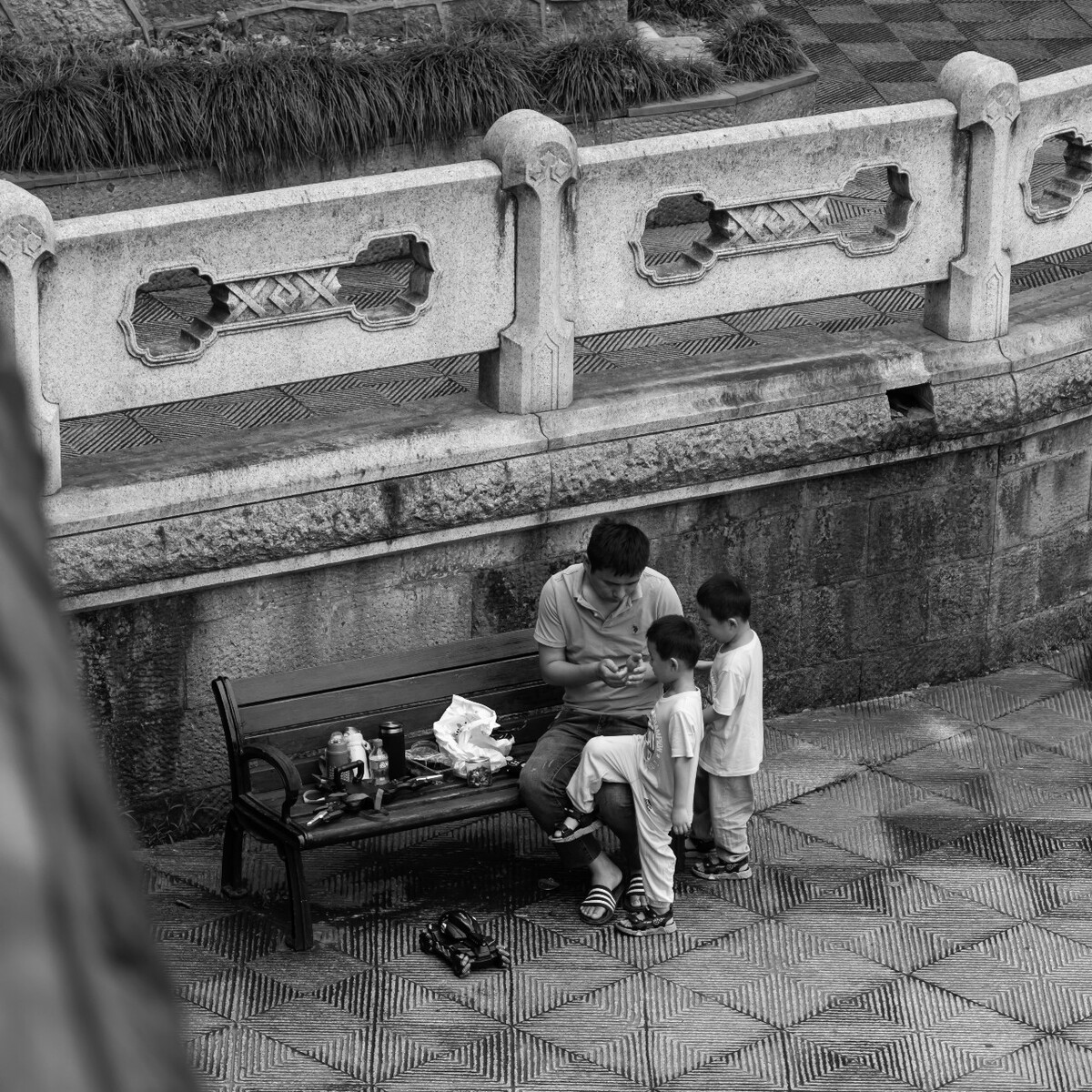 2021.06.26 杭州 机场路拍摄。 父亲陪着双胞胎儿子在河边的椅子旁玩耍。