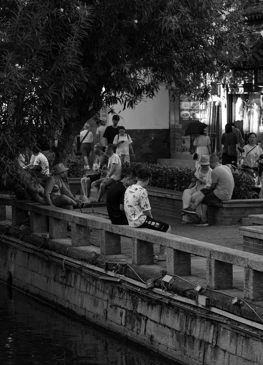 2021.07.19 苏州 楼门内大街所拍摄。和朋友扫街西北街周边街巷,在楼门内大街拍摄到这张照片,河边坐着很多对一块的人们。