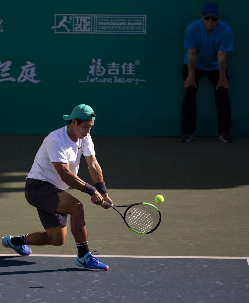 网球运动员击球的瞬间动作刚好是在画面的最亮处既强化了主体又通过