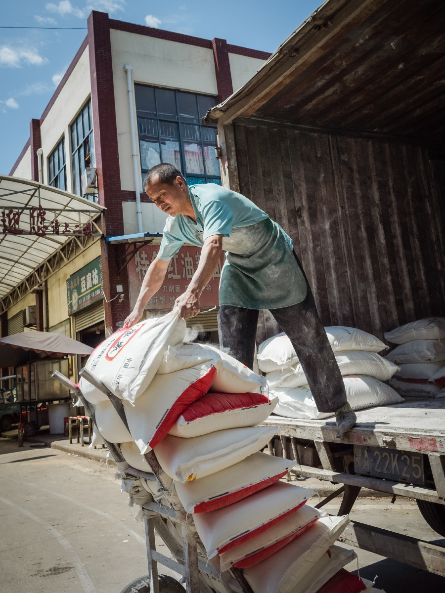 2019年5月8月武汉黄陂横店卸货的师傅正在搬运面粉整车面粉都是他一个