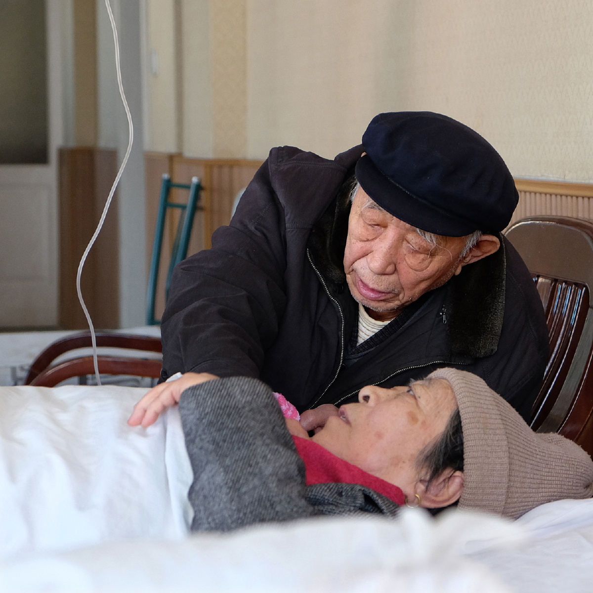 病床上,一对老夫妻相濡以沫,互相照应,患难中见真情.