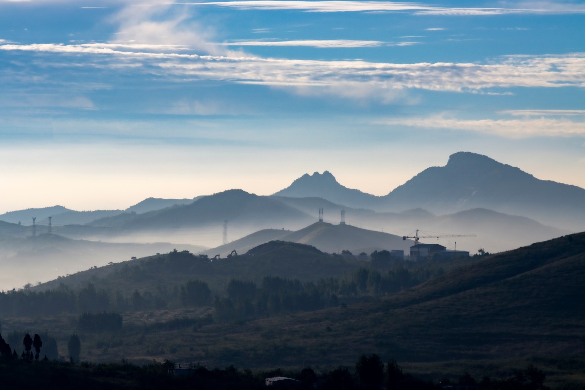 初秋的济南钢城区的早晨雨后初晴青山如黛村庄隐约在平流雾中如同仙境
