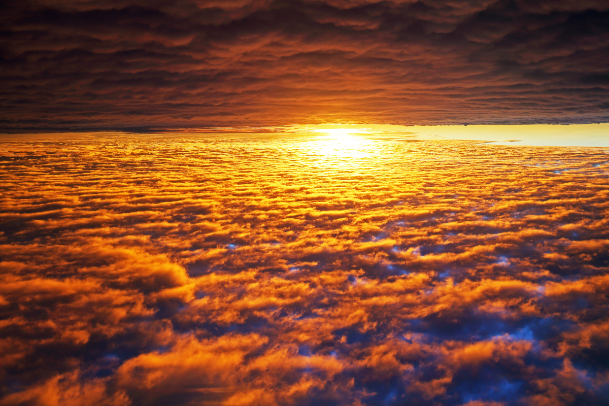 黄昏,飞机突破云层的瞬间,阳光照射云层,形成金黄的河流.