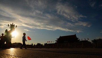 2015年6月11日，北京，一男孩在夕阳的余晖下走过天安门广场。