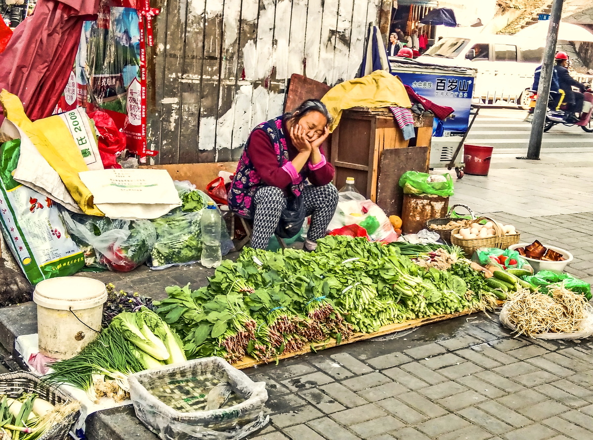 2016年3月6日,湖北宜昌市街头,一个卖菜的老人在中午没人光顾菜摊时打