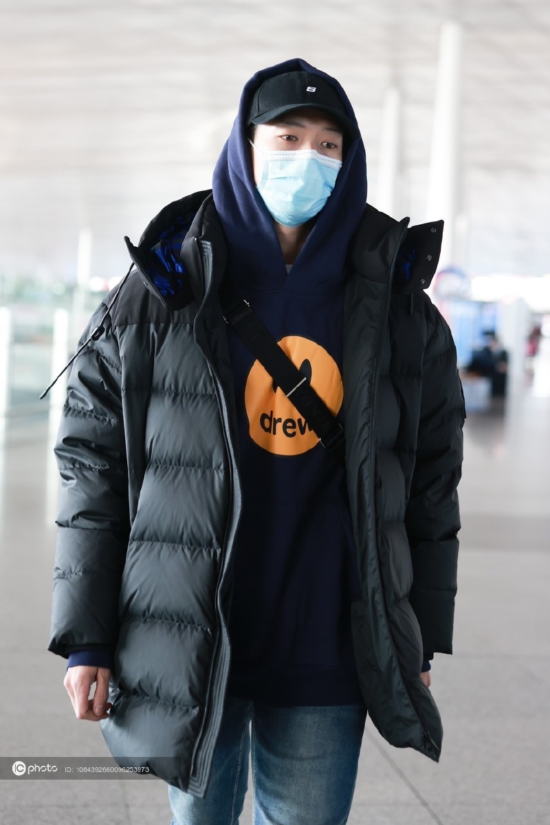 街拍魏大勋戴棒球帽套帽衫包包挎在羽绒服外套里