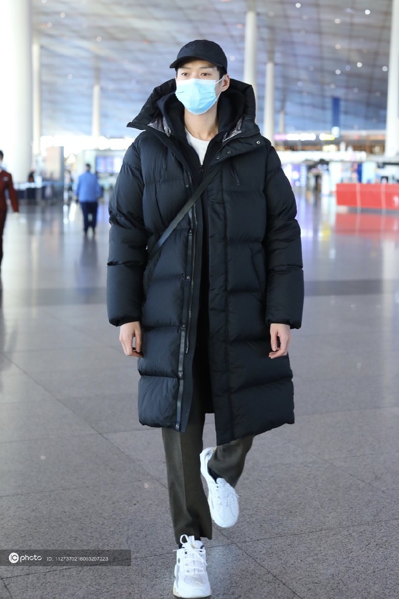 街拍魏大勋黑色长款羽绒服休闲裤白色运动鞋棒球帽休闲随性