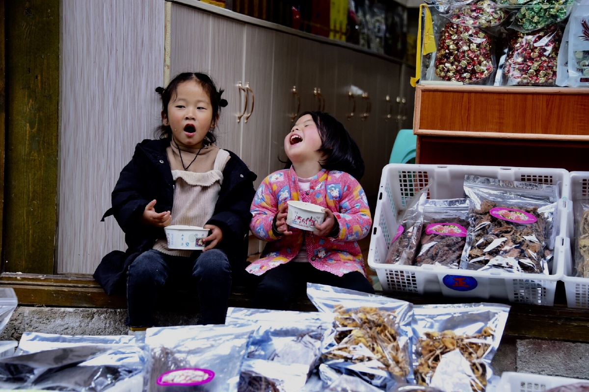 路边摊的小女孩,吃着麻辣烫,满满的幸福感.摄于磨西古镇.