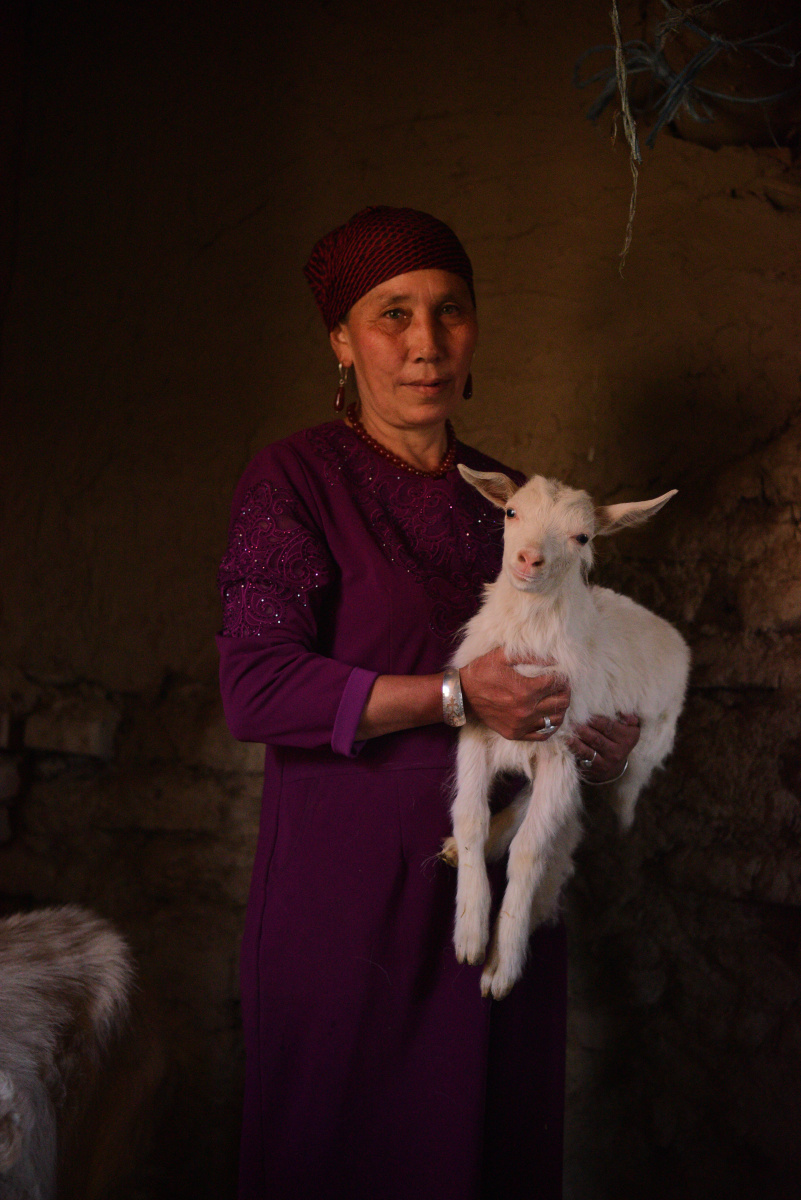 抱着小羊羔的哈萨克族妇女