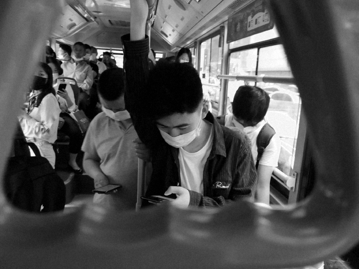 公交车玩手机的年轻人