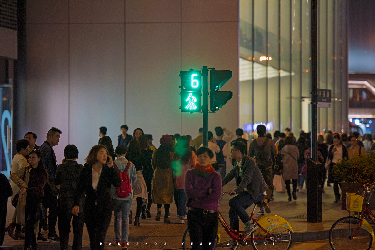 杭州夜晚的街景,东坡路红绿灯旁的人们
