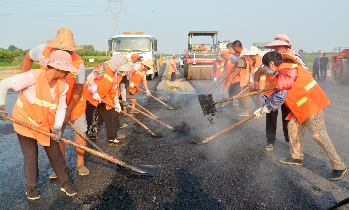 烈日下工作在一线的筑路工人